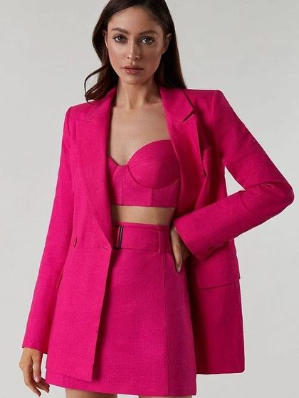 This super cute skirt power suit in a vibrant fuchsia includes a matching blazer, a belted mini skirt, and a bustier top.