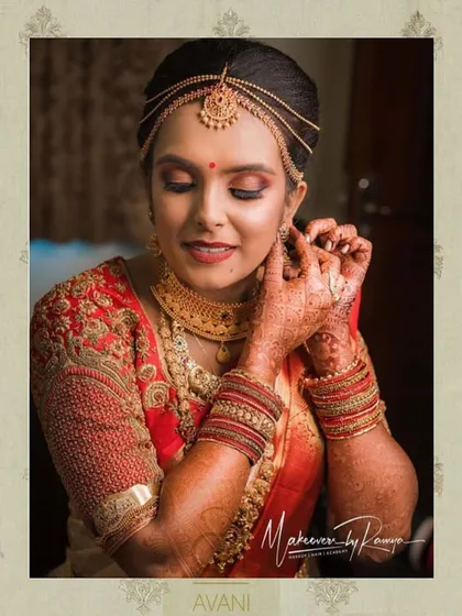 A bride getting ready for her muhurtham. Her red blouse is heavily embroidered with gold thread, a classic and timeless choice for a South Indian wedding.
