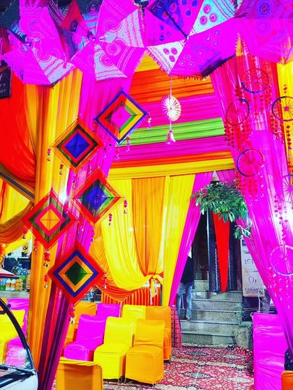 A close-up of the tent's entrance decor, featuring hanging dreamcatchers, umbrellas, and layered drapes.