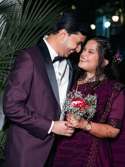 A groom surprises his bride with a bouquet of flowers at their reception.