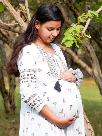 A classic maternity pose with the mother-to-be cradling her belly. This shot beautifully captures the bond between mother and unborn child.