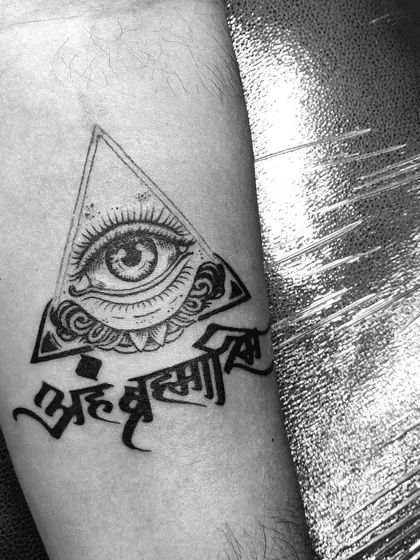 A closer look at the "Aham Brahmasmi" and all-seeing eye tattoo. The clean linework and dotwork shading create a sharp, impactful design.