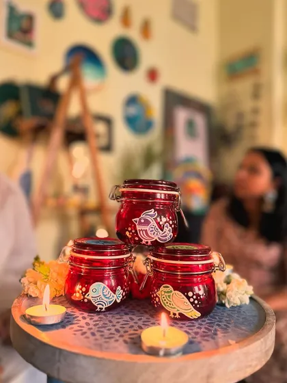 A set of red clip-lock jars painted with simple, elegant bird motifs.
