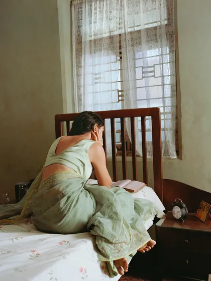 The same character in her bedroom, reading a book. These quiet, narrative scenes help build a complete world for the campaign, making the clothing feel lived-in.
