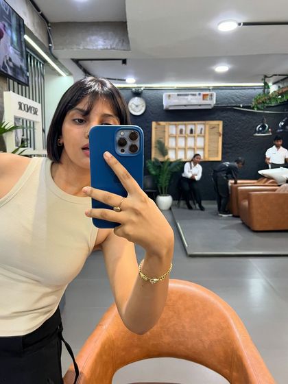 The client taking a mirror selfie to capture her fresh new short haircut. We love seeing our clients feel confident and happy.