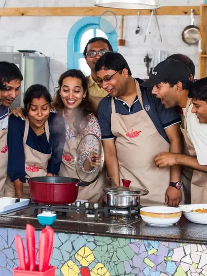The big reveal! A team gathers around to see the results of their hard work simmering on the stove. That shared sense of accomplishment is what makes these events so special.