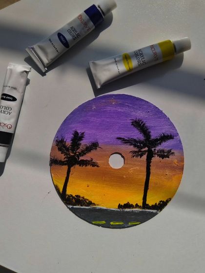 Another one of my CD paintings, this time a sunset scene with palm tree silhouettes. The compact disc makes for a unique and reflective canvas.