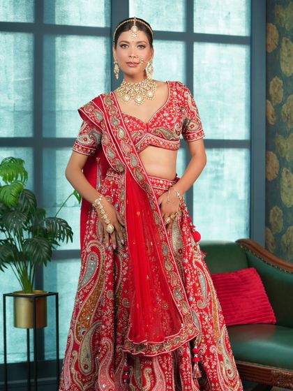 This stunning red lehenga features intricate paisley and floral embroidery. It’s a perfect example of the designer-quality ethnic wear you can rent for your wedding.