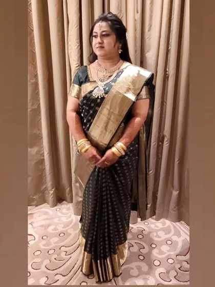 The rich contrast of black and gold on this Kanjeevaram is simply stunning. The pre-set pleats ensure the saree's beauty is on full display.