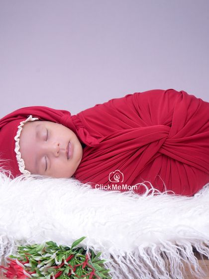 A close-up portrait from the Christmas session, focusing on the baby's serene face and the soft textures of the swaddle and hat.