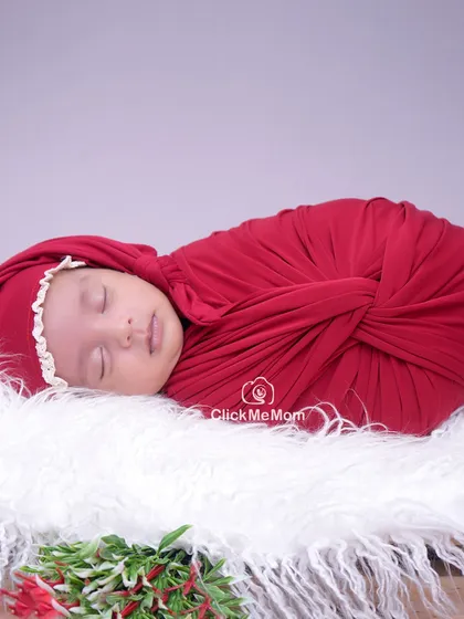 A close-up portrait from the Christmas session, focusing on the baby's serene face and the soft textures of the swaddle and hat.
