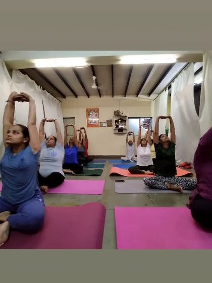 A moment of collective stretching in a group class. We are all working on lengthening our spines and opening our shoulders, creating a unified and focused atmosphere.