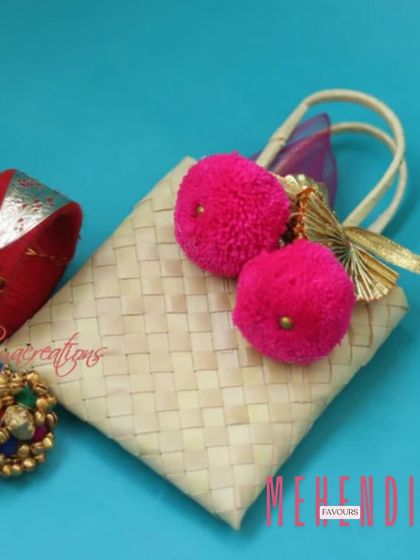 For a rustic and charming Mehendi favour, I love these small woven palm leaf bags. The bright pink pom-poms add a fun pop of color, making them perfect for a vibrant celebration.