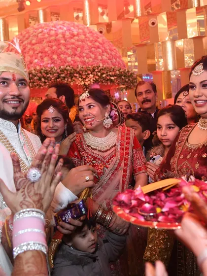 The couple's grand welcome. Surrounded by family and showered with petals, their happy faces tell the story of the celebration.