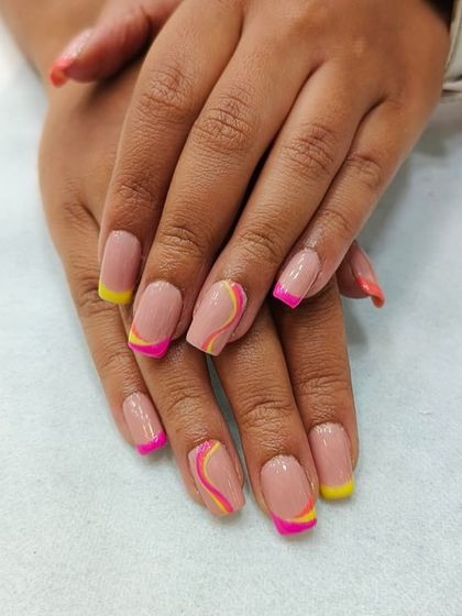 Fun and vibrant nail art perfect for summer. This design features a nude base with playful pink and yellow French tips and abstract swirls, showcasing our ability to create modern and colorful looks.
