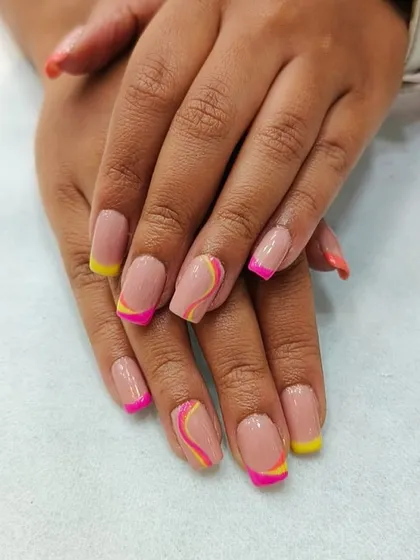 Fun and summery nails with pink and yellow French tips and swirl accents. We encourage our students to play with color and design.
