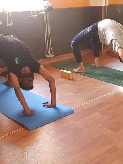 Practitioners here are working on Chakrasana, or Wheel Pose. I provide guidance for advanced postures like this to help students safely deepen their practice and enhance spinal flexibility.