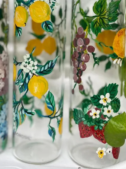A close-up of the hand-painted Borosil bottles, showing the delicate brushwork on the lemons and strawberries.
