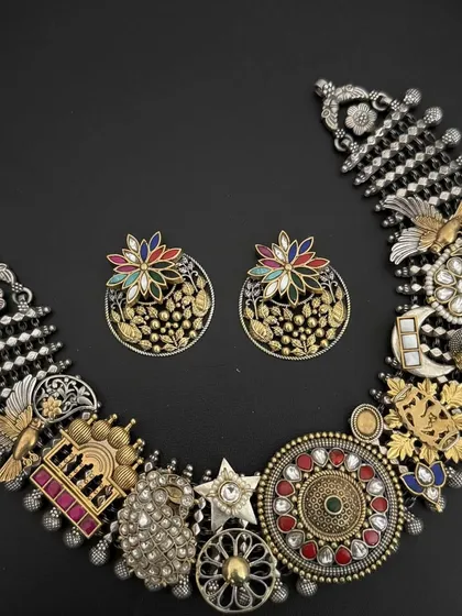This is what my fusion style is all about. An intricate 925 silver necklace set that brings together dozens of different motifs, from birds and flowers to stars, blending oxidised silver with gold-plated touches and colourful stones.