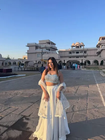 A beautiful white lehenga with a sparkling silver blouse, styled for an elegant day wedding or a festive event.
