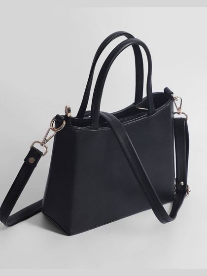 The side profile of the black handbag.