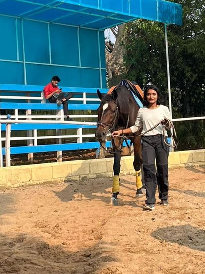A student leads her horse in the arena. Learning to handle the horse on the ground is just as important as riding, and we incorporate it into our lessons.