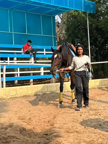 A student leads her horse in the arena. Learning to handle the horse on the ground is just as important as riding, and we incorporate it into our lessons.