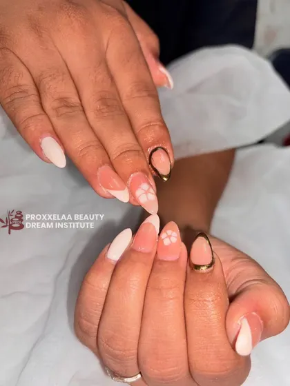 A minimalist and elegant design on almond-shaped nails. This set combines a soft, milky white base with delicate hand-painted flowers and a modern gold-outlined accent nail.