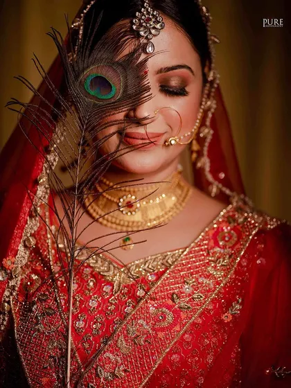A creative bridal portrait using a peacock feather. This artistic touch adds a unique and symbolic element to the photograph.