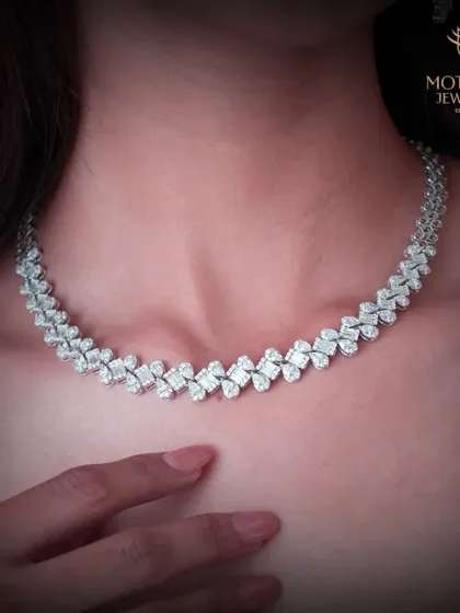 A classic diamond necklace with a delicate, leaf-like pattern. This is a versatile and timeless piece, perfect for adding a touch of sparkle to both formal and casual attire.