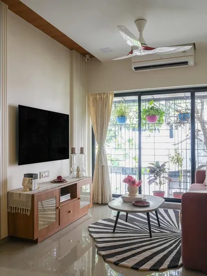 The transformed living room of the Vora House. By swapping the TV and dining areas, we created a much more functional layout with a clear, defined living space that feels open and modern.