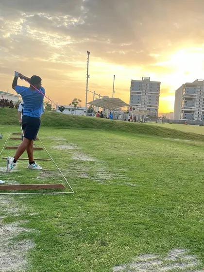 A golfer takes a swing from our natural grass tee area, designed to give you the feel of playing on a real course fairway.