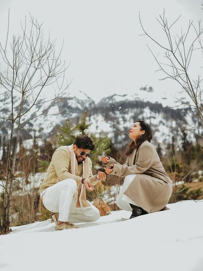 A playful moment in the snow during a post-wedding shoot, capturing the fun side of the newly married couple.