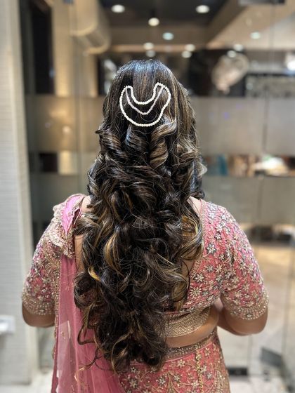 A beautiful open hairstyle with voluminous curls and a modern pearl hair accessory.
