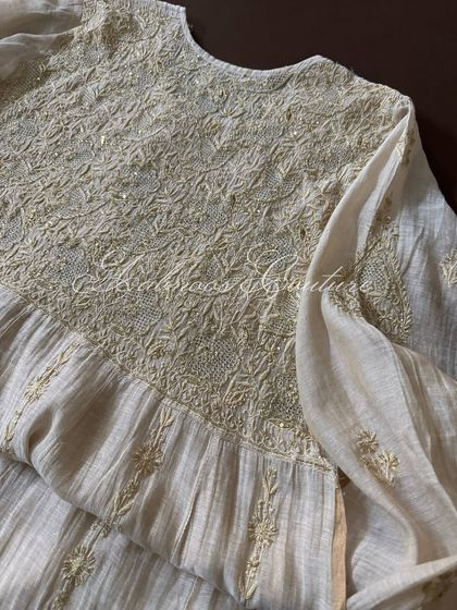 A detail shot of the peplum-style flare of the Tissue Chanderi Anarkali, highlighting the texture of the fabric and the kasab work.
