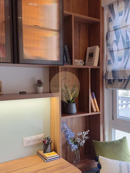 A cozy study and office space with a custom desk, open shelving, and a comfortable window seat.
