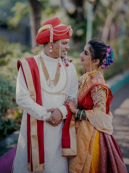 A classic portrait of a Maharashtrian couple. The groom in his 'pheta' and the bride in her traditional saree share a look of love, a timeless moment from their 'lagn'.