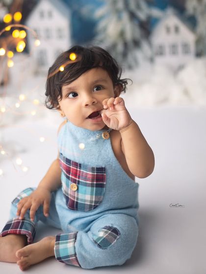 Every small expression is so precious. This little boy's thoughtful look and tiny hand make for a beautiful, candid moment in this winter setup.