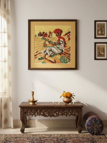 The framed needlepoint art, beautifully situated in a traditional Indian-style interior. Our framing helps integrate a personal creation seamlessly into a home's decor, turning a hobby into a piece of cherished art.