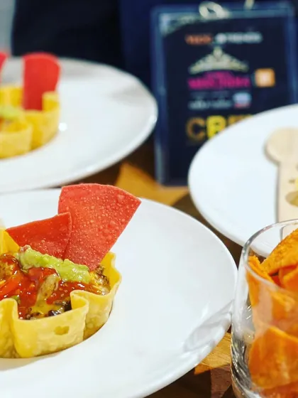 A deconstructed taco bowl served at the Femina Miss India event, featuring a crispy tortilla shell filled with beans, salsa, and guacamole.