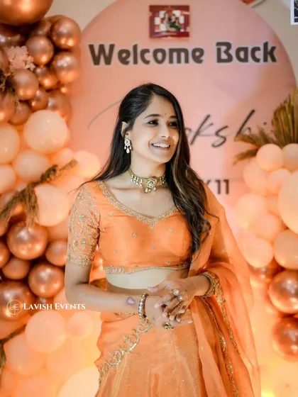 A beautiful shot of Mokshitha Pai at her welcome home party. The soft lighting and peach tones of the decor perfectly complement her traditional attire.