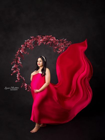 A beautiful composition featuring a flowing pink gown and a delicate floral hoop. The contrast against the black background makes the colors pop.