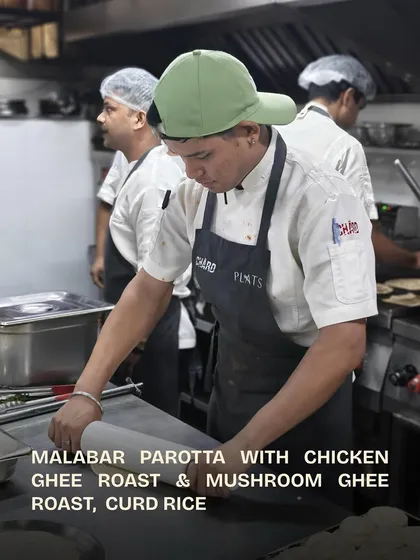 A chef carefully rolling out the dough for Malabar Parottas.