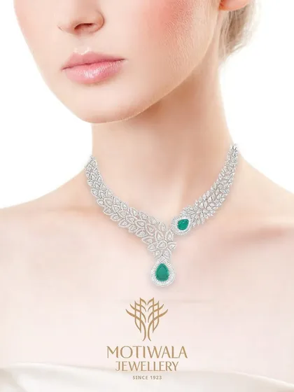 Inspired by nature's delicate forms, this diamond and emerald necklace is for the modern woman who appreciates subtle luxury. The pear-shaped emerald drop adds a touch of color to the intricate, leaf-like diamond setting.