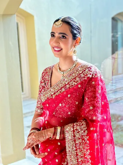 Another angle of this timeless bride. Her makeup is subtle, allowing her happiness and the beauty of her red saree to take center stage.