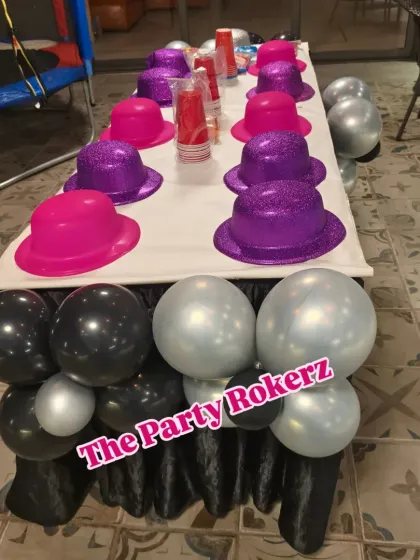 A fun detail from a terrace party, showing a kids' table decorated with a balloon base and glittery party hats for the young guests.