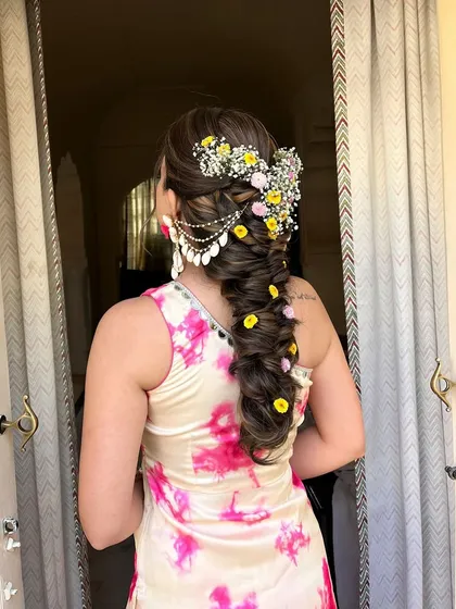 A side view of the floral and shell-adorned braid. The combination of colors and textures is perfect for a beachside or destination wedding event.