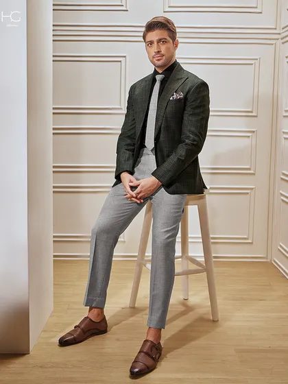 A business suit should have character. This checked blazer in green and grey, paired with tailored trousers and fine leather shoes, is a perfect blend of classic power and modern style for the discerning professional.