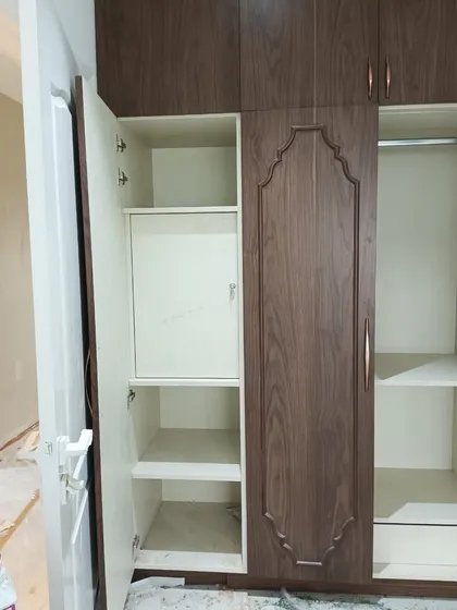 A look inside the custom wardrobe, showing the functional interior layout with dedicated compartments and a built-in locker. We design the inside of our wardrobes to be as thoughtful as the outside.