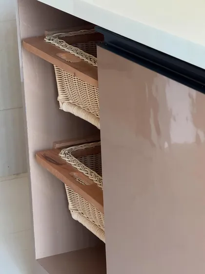 A smart storage detail: pull-out wicker baskets for vegetables. These are integrated directly into the cabinetry, ensuring good ventilation and easy access.